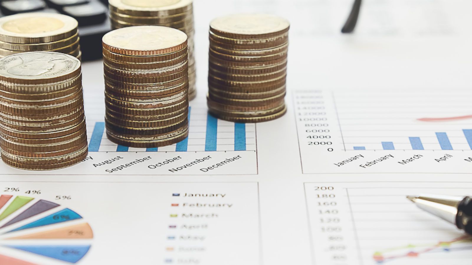 Stacked coins with financial charts showing revenue growth and shopping’s impact on airline revenue management.