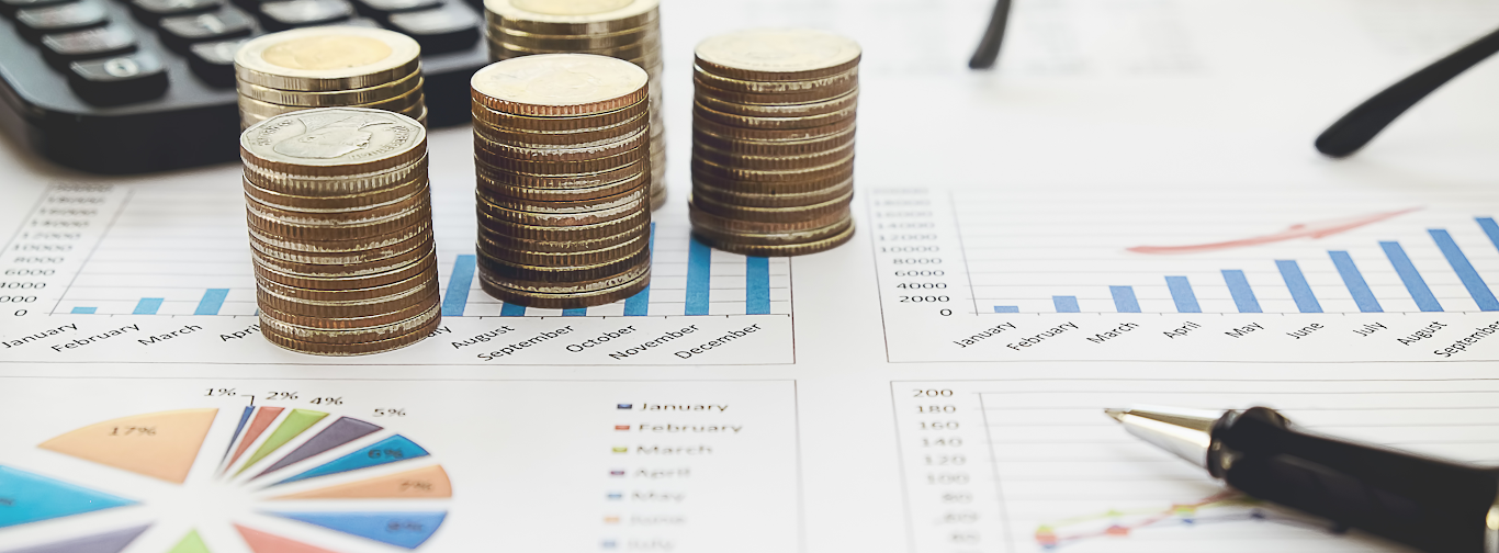 Stacked coins with financial charts showing revenue growth and shopping’s impact on airline revenue management.