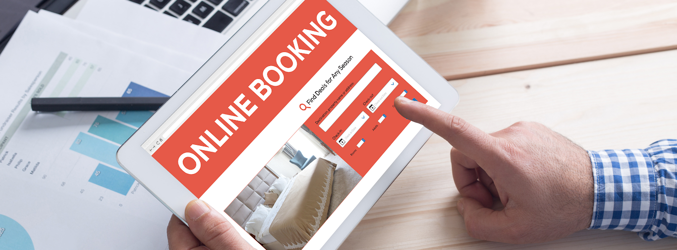 Traveler using online booking system on tablet to create dynamic travel packages for hotels and flights.