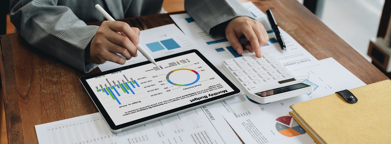 Travel manager analyzing budget charts on tablet and calculator to optimize profits with 80/20 rule.