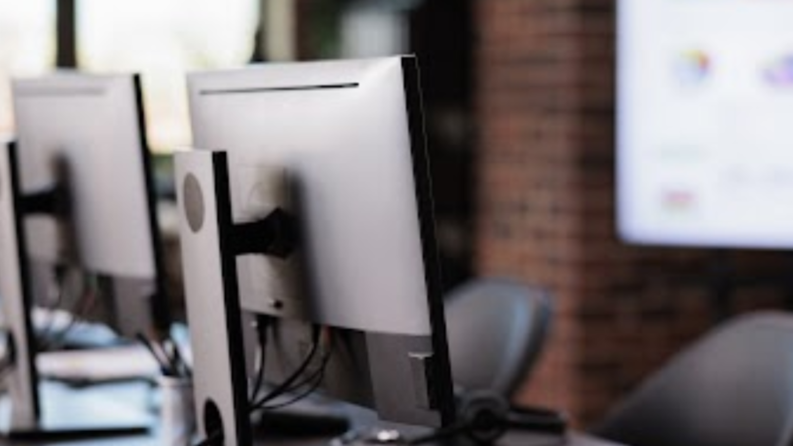 Row of desktop computers in travel office representing computer reservation systems for bookings.